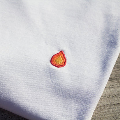 Zoomed-in detail of the flame pattern on a folded Out Now! white t-shirt.