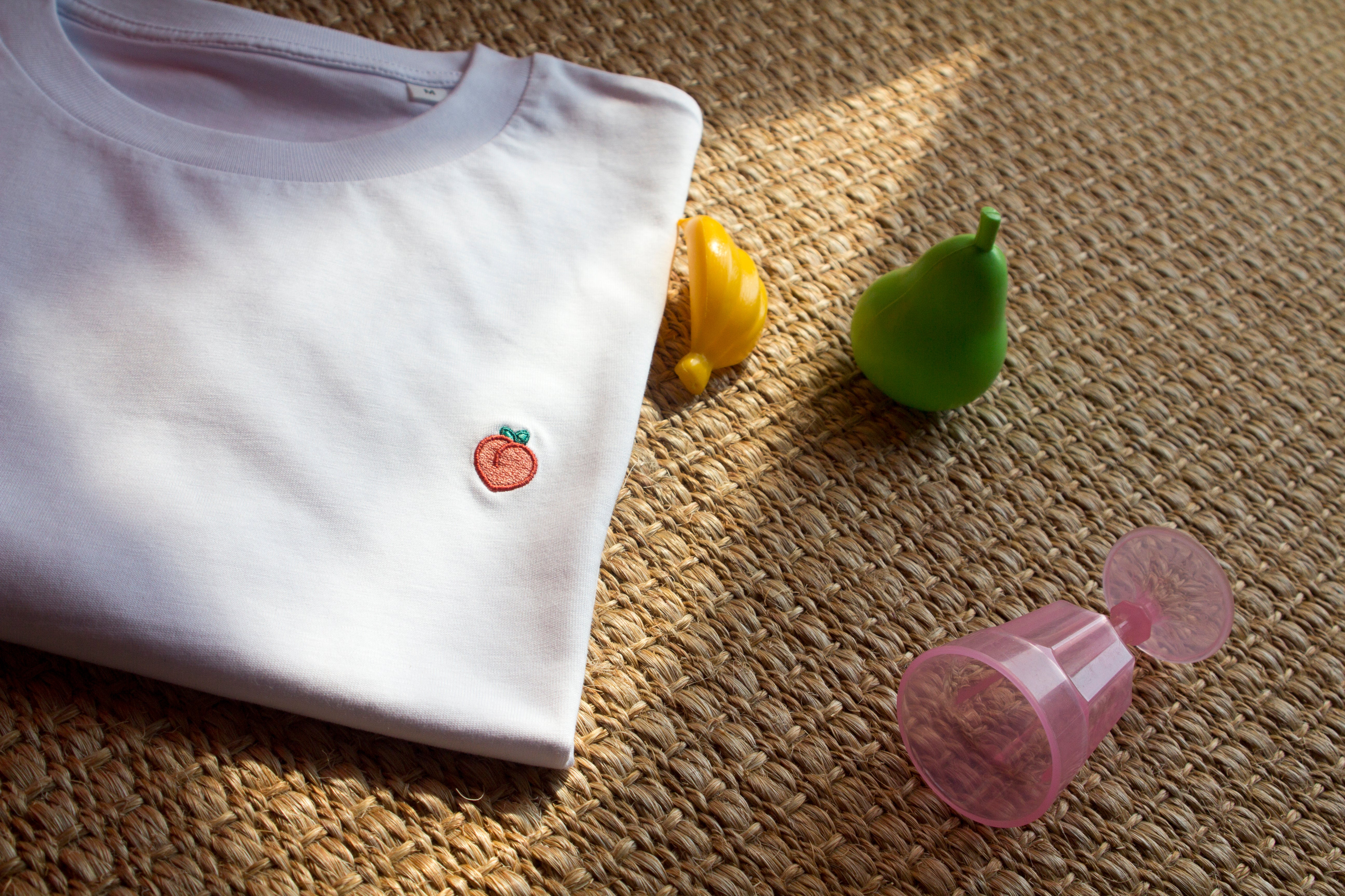 Out Now! t-shirt featuring a peach pattern, styled in a vibrant ambiance, highlighting its unique LGBTQ+ fashion appeal.